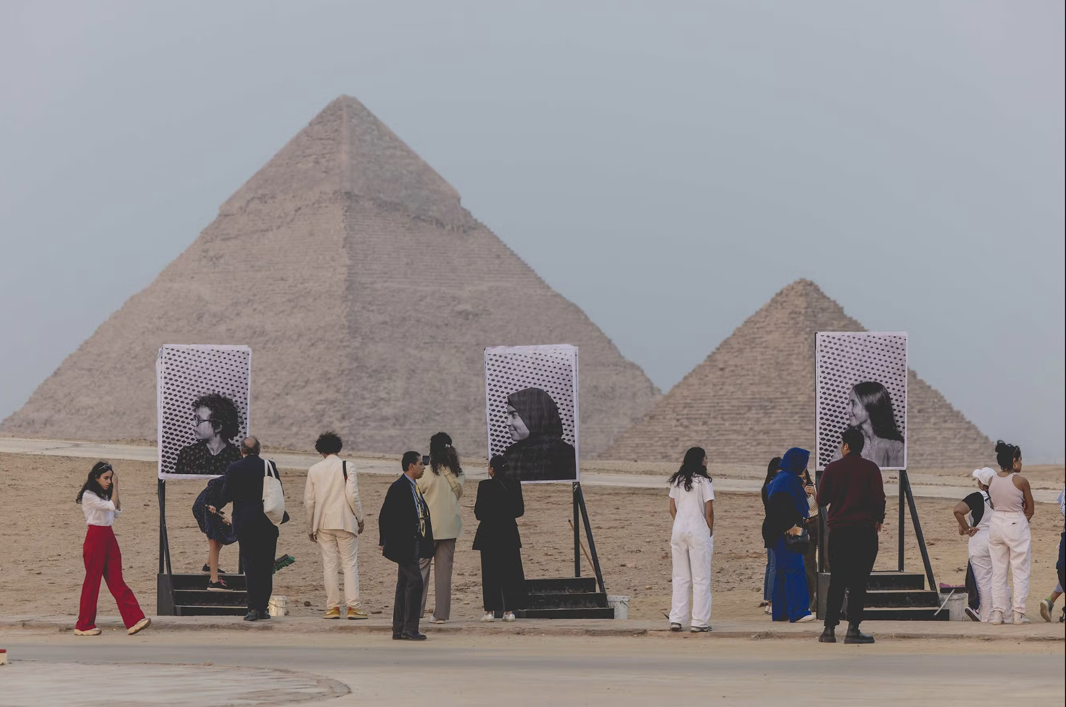 Participants admiring portraits at Forever Is Now II, Giza, Egypt, 2022. © Justin Weiler.