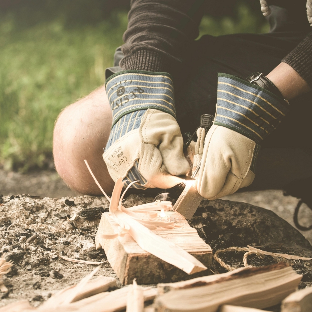 Team building survival workshop, person making fire with sticks