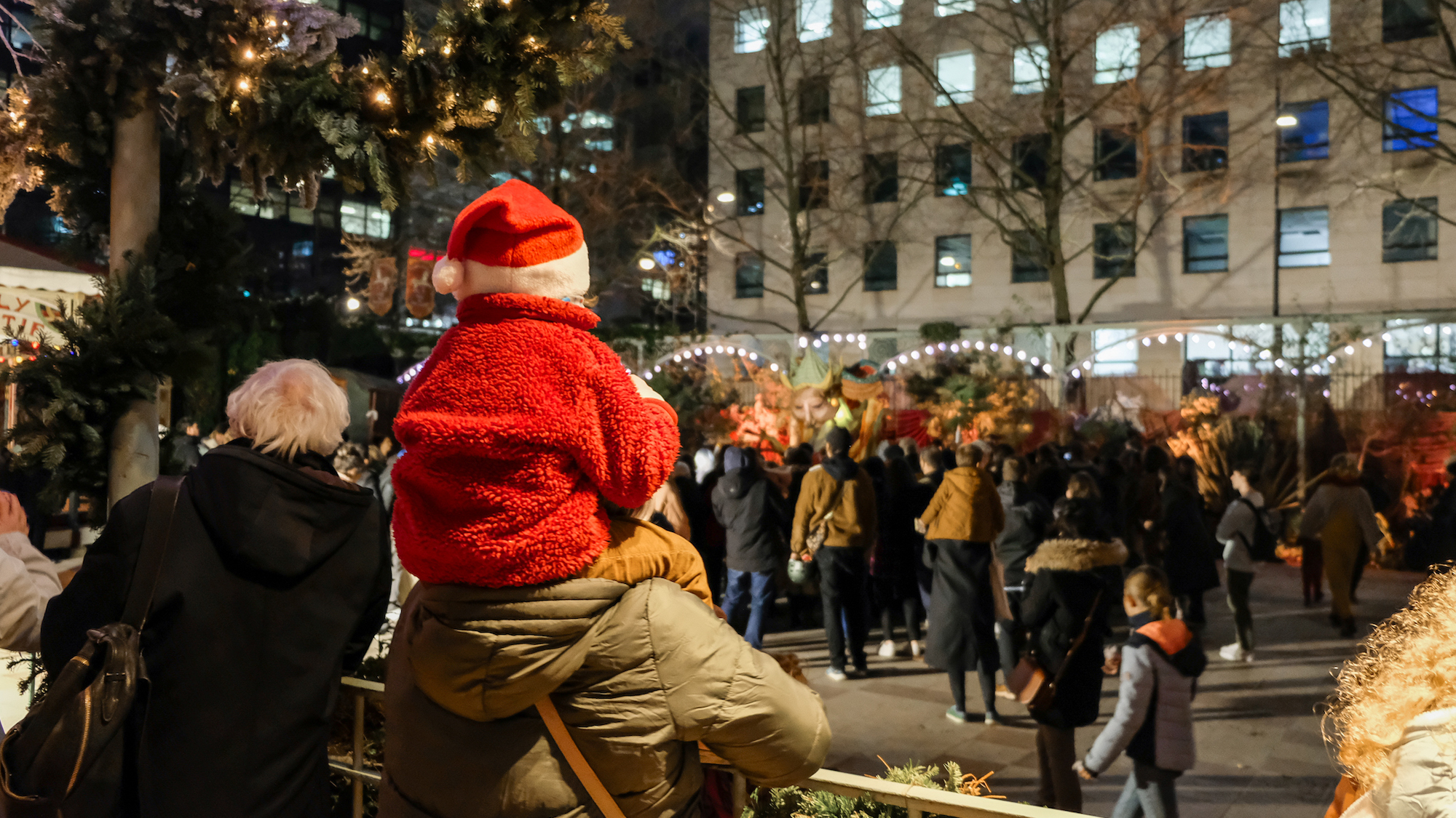 enfant-avec-un-bonnet-de-noel-sur-les-epaules-d-un